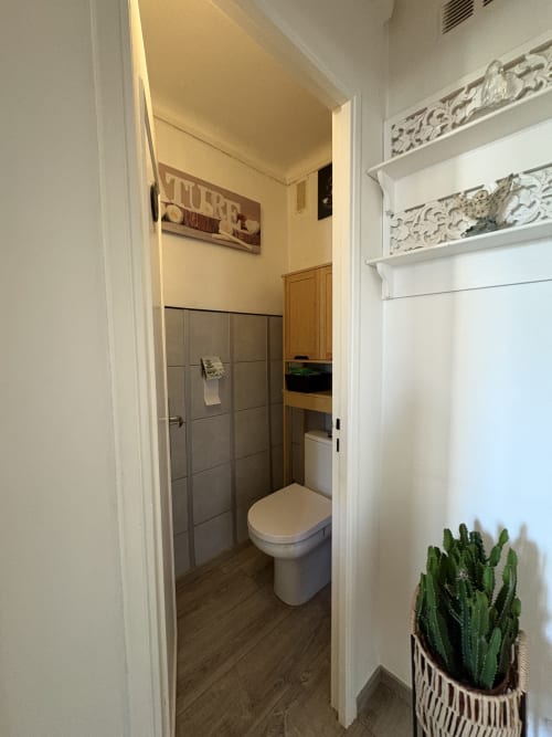 Salle de bain moderne de la chambre Le Cocon Arlésien à la Conciergerie Maurin à Arles avec douche carrelée et étagères décoratives