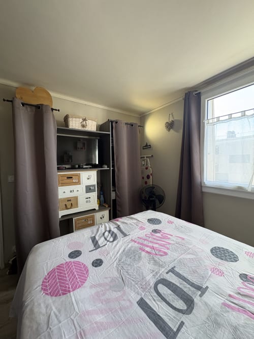 Chambre douillette à la Conciergerie Maurin à Arles avec lit, rangements et fenêtre sur la ville