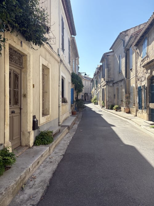 Rue pittoresque en pierre à Arles avec bâtiments traditionnels et lierre, quartier de l'hôtel Conciergerie Maurin