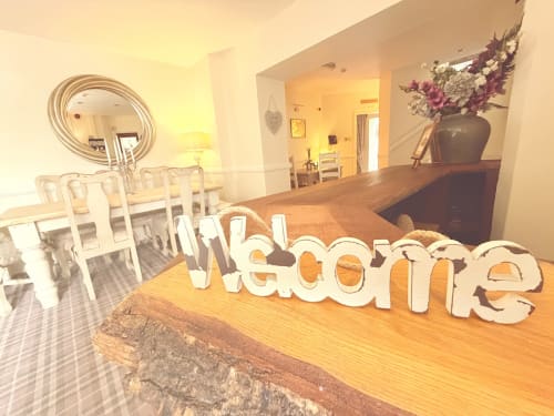 Welcome sign in luxury Usk Guest House apartment in Brecon with dining area and elegant decor
