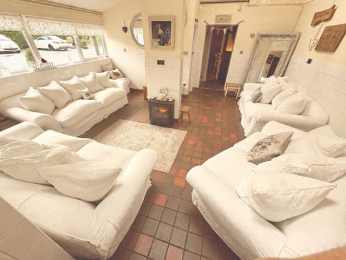 Spacious luxury apartment at The Usk Guest house in Brecon with cream sofas, fireplace, and red-tiled floors