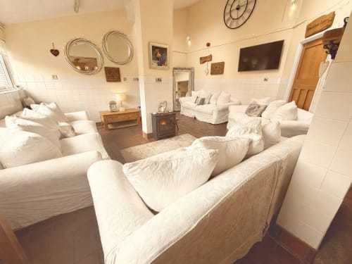 Spacious luxury apartment lounge at The Usk Guest house in Brecon with cream sofas, fireplace, and mountain views