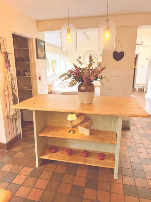 Warm kitchen with wooden island, dried flower arrangement, pendant lights, and terracotta tile flooring at The Usk Guest