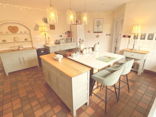 Luxury kitchen in The Usk Guest House, Brecon: cream cabinetry, wooden countertops, island seating, pendant lighting, and