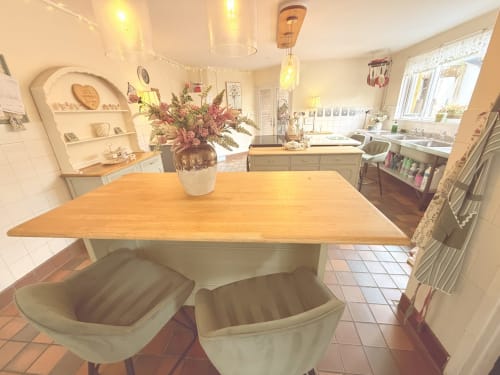 Bright luxury kitchen with wooden island, green seating, and dried flowers at Usk Guest house B&B in Brecon