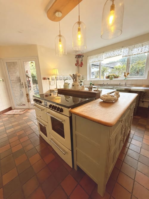 Luxury kitchen with cream range cooker, wooden countertop island, pendant lights, and mountain views at The Usk Guest House,