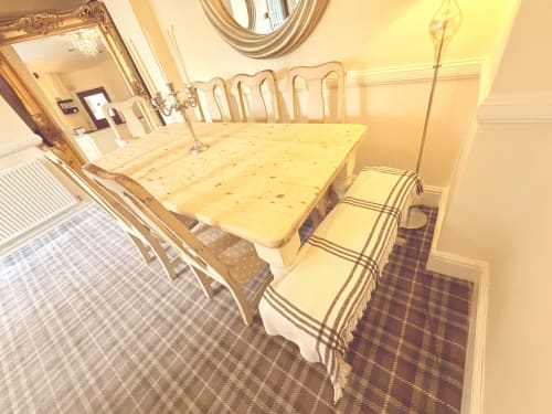 Elegant dining room at The Usk Guest house in Brecon with wooden table, striped chairs, and warm lighting overlooking