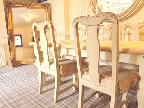 Elegant dining area at The Usk Guest House in Brecon with cream Queen Anne chairs and gold-framed mirror.