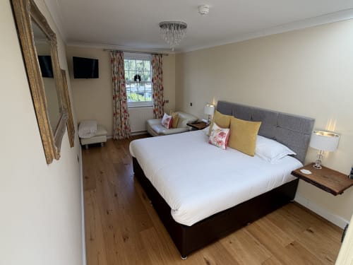 Luxury bedroom at The Usk Guest house in Brecon with king bed, mountain views, elegant décor, and en-suite bathroom