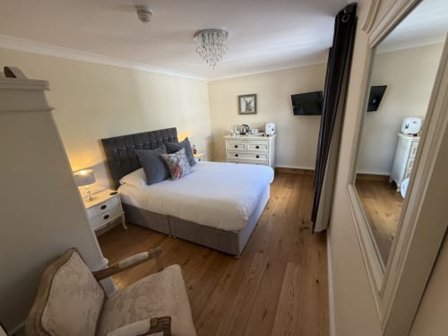 Luxury bedroom at The Usk Guest House in Brecon with queen bed, en-suite bathroom, and mountain views