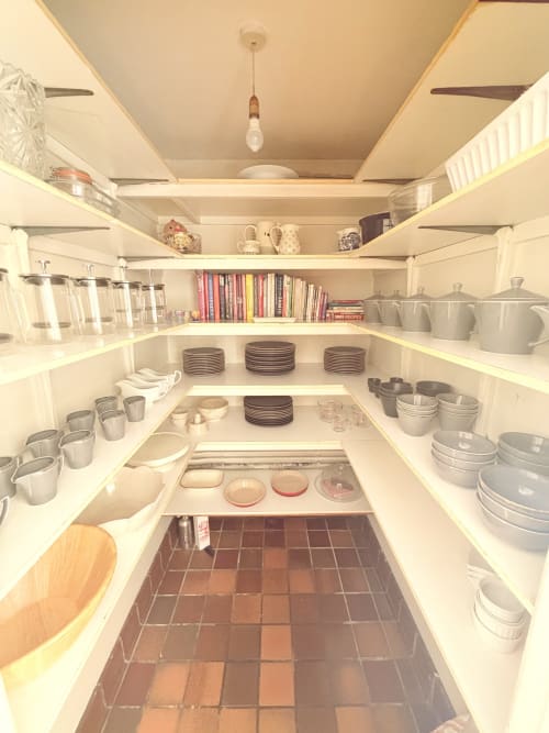 Organized kitchen pantry with white shelving, dishes, cookbooks, and glassware at The Usk Guest house, Brecon