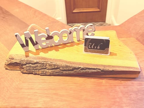 Welcome sign with 'Usk' nameplate on rustic wood base in The Usk Guest house, Brecon