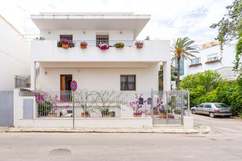 Moderno edificio bianco a Otranto con fiori colorati sui balconi e terrazza, alloggio con 2 camere da letto