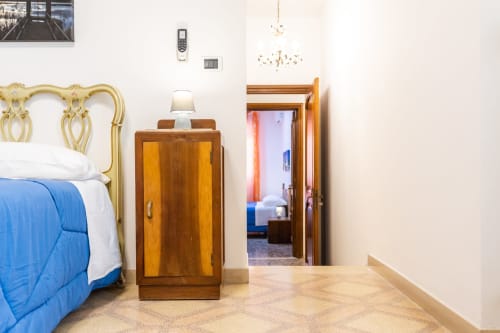 Camera da letto dell'Otranto Oasis con testata in ottone, comodino in legno e porta verso la stanza adiacente