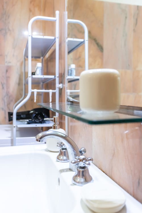 Lavabo moderno con rubinetto cromato nell'appartamento Otranto Oasis, con schienale in marmo e specchio