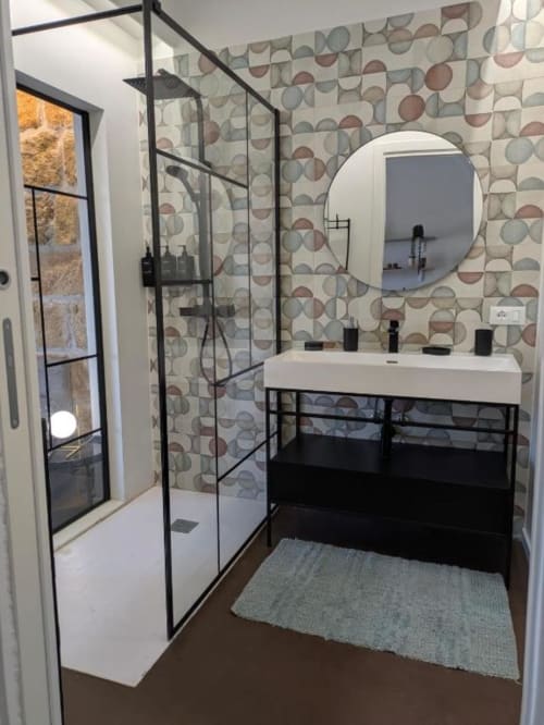 Bagno moderno in BnB del Parlamento Palermo con pareti geometriche piastrellate, doccia con cornice nera, specchio rotondo e