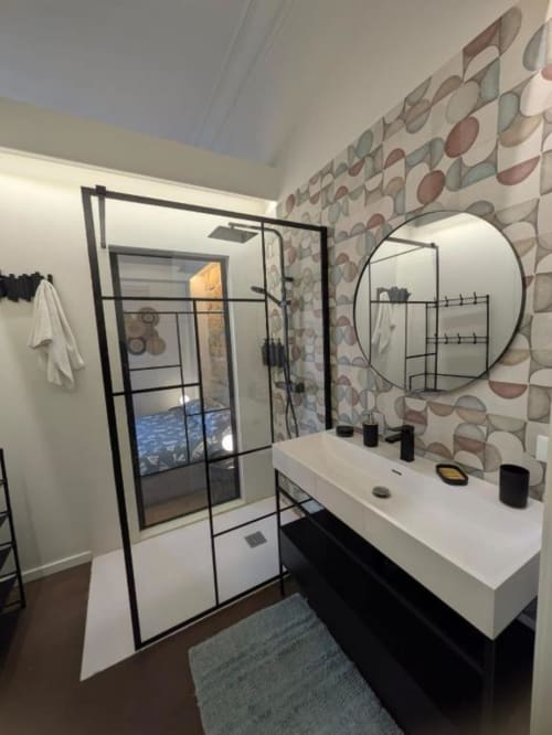 Bagno moderno della BnB del Parlamento Palermo con specchio rotondo, lavabo bianco, vanity nera e doccia walk-in con griglia