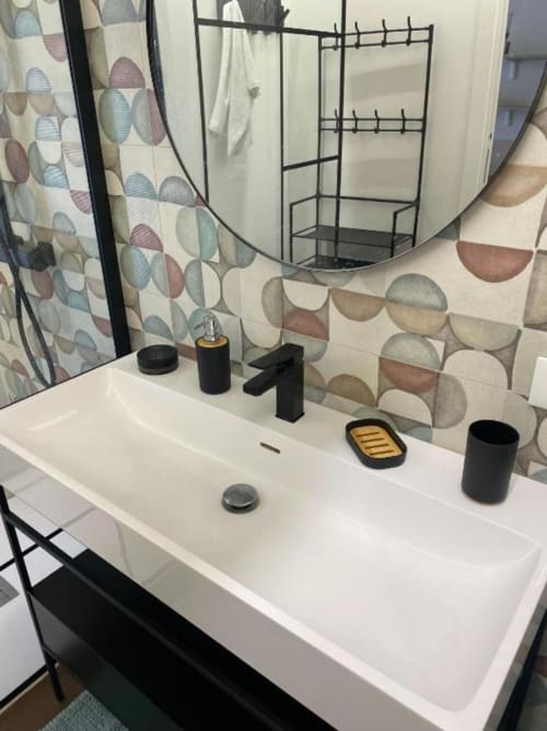 Lavabo moderno con rubinetteria nera al BnB del Parlamento Palermo, con rivestimento geometrico in piastrelle e specchio