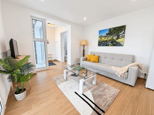 Modern living room at Check Madeira Sunshine House 85 villa in Ribeira Brava with gray sofa, wooden floors, and sea views
