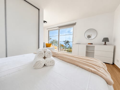 Bright bedroom at Check Madeira hotel in Ribeira Brava with sea view, rolled towels, and modern minimalist decor