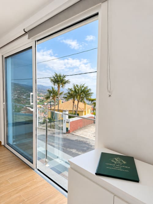 Modern balcony door at Check Madeira hotel in Ribeira Brava with palm trees and mountain views