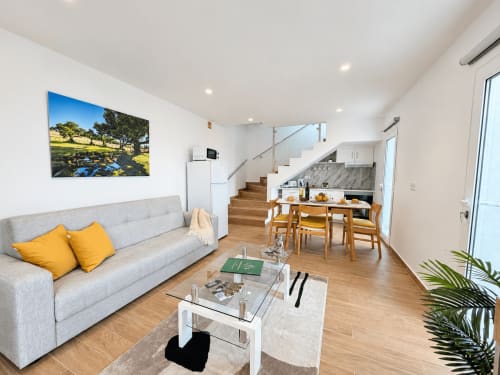 Modern living room at Check Madeira in Ribeira Brava with gray sofa, dining area, and staircase