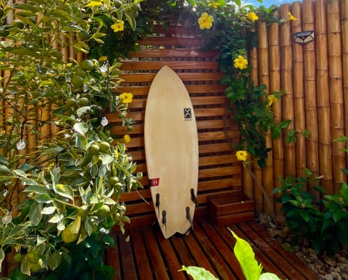 Cream surfboard displayed in tropical garden at Malù Surf Boutique Hôtel, Canoa Ecuador