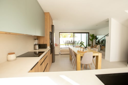 Cocina y comedor de planta abierta en Villa MERAKI con muebles de madera, mesa de comedor y vistas hacia la terraza