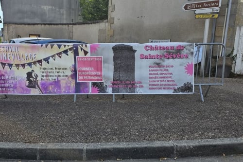 Promotional banners for Château de Sainte-Sévère and village festival events displayed near French countryside accommodation