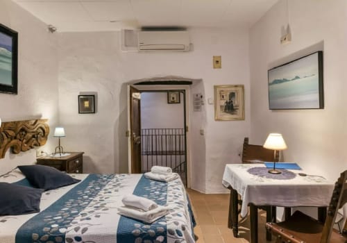 Dormitorio amplio en casa rural Can Gat Vell, Saus, con camas gemelas, aire acondicionado, TV, vistas al jardín y decoración tradicional