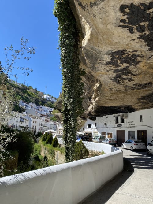 Entrada del hotel Posada Alegría bajo espectacular acantilado rocoso en Medina-Sidonia, Cádiz
