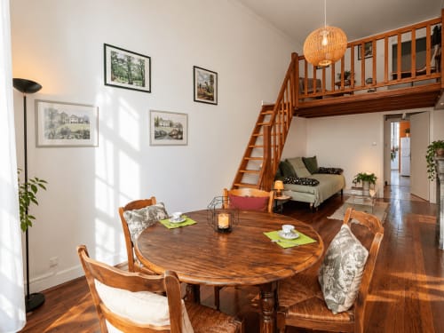 Suite mezzanine à Au Bon Gîte à Senones avec table à manger, escalier en bois et chambre à l'étage
