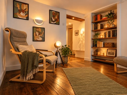 Séjour douillet à Au Bon Gîte Senones avec mobilier en bois, œuvres d'art, bibliothèques et éclairage ambiant chaleureux