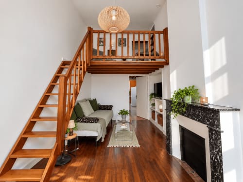 Suite mezzanine moderne à Au Bon Gîte à Senones avec escalier en bois, cheminée et coin salon confortable