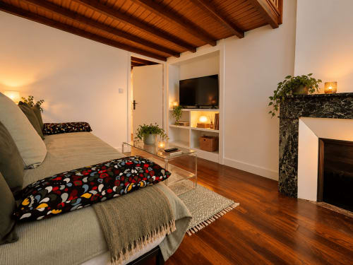 Suite mezzanine chaleureuse à Au Bon Gîte à Senones avec poutres apparentes, lit, cheminée, TV et plantes