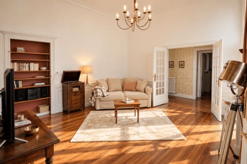 Élégant séjour de la suite Executive Prince de Salm à Au Bon Gîte, avec canapé beige, mobilier en bois, cheminée et