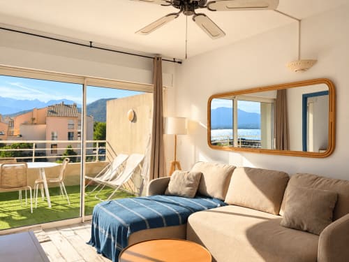 Appartement ensoleillé face mer à L'Île-Rousse avec vue sur la mer, terrasse, sièges confortables et montagnes en arrière-plan