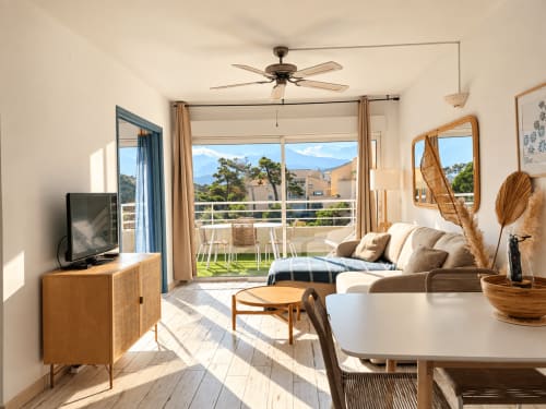 Lumineux appartement à L'Île-Rousse avec vue mer, séjour moderne, TV, assises confortables, salle à manger et terrasse aménagée