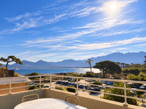 Terrasse ensoleillée avec vue sur la baie de L'Île-Rousse, montagnes et littoral méditerranéen depuis appartement T3