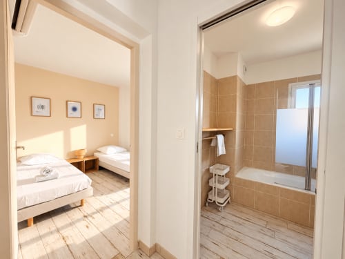 Chambre et salle de bain lumineuses dans un appartement en bord de mer à L'Île-Rousse avec vue sur la mer