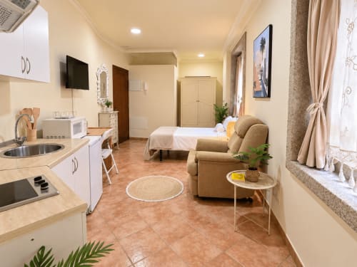 Luminoso apartamento estudio en Baiona con cocina americana, cama, sillón, TV y suelo de baldosa de terracota