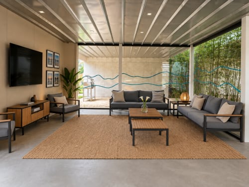 Salón moderno con sofás grises, muebles de madera, televisor y vistas al jardín en Holibai, Baiona