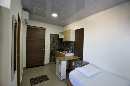 Habitación moderna en Vamos pa San Andrés Isla con cama, cocina, detalles de madera y vistas al mar