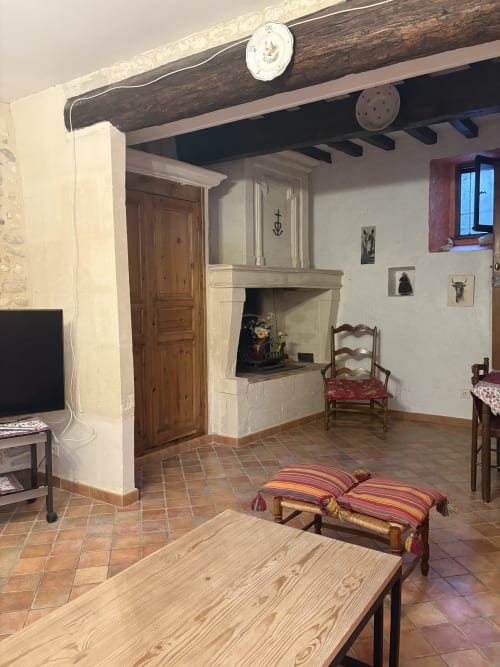 Salon de maison arlésienne rustique à Arles avec poutres apparentes, cheminée, mobilier en bois et décor traditionnel