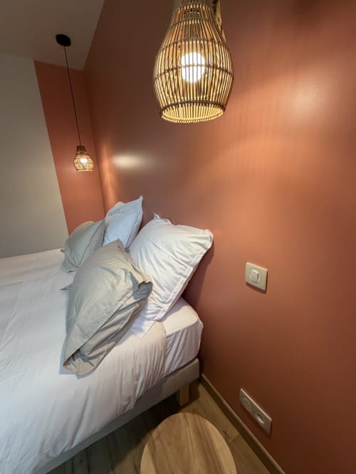 Chambre moderne à La cour des Agapanthes, Bain de Bretagne, aux murs terre cuite, luminaires suspendus tissés et blanc