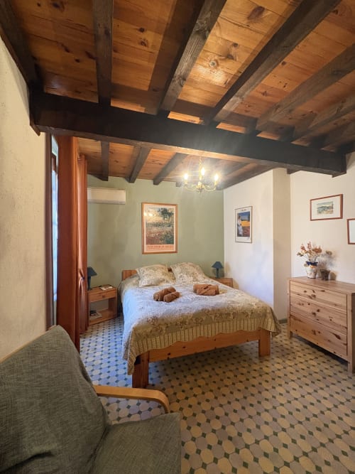 Chambre rustique à Arles avec poutres apparentes, lit queen-size, meubles en pin et carrelage bleu motifs