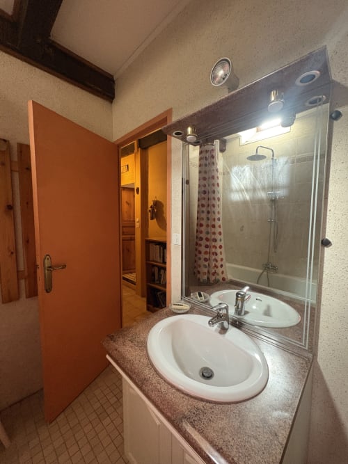 Salle de bain moderne avec double vasque, grand miroir et douche à l'italienne dans location vacances à Arles