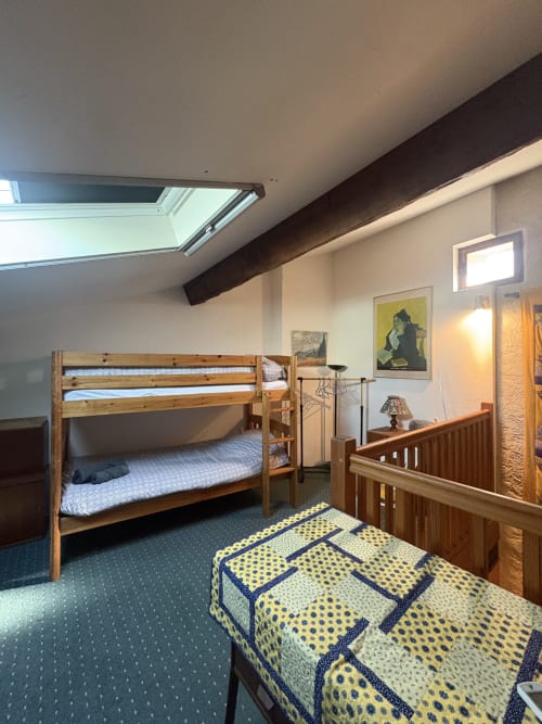 Chambre spacieuse dans une maison d'hôtes à Arles avec lit superposé, lit simple, puits de lumière, poutres en bois et plafond mansardé