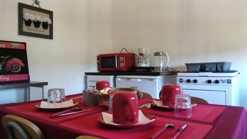 Sala de jantar Maison de Barlest com mesa vermelha, eletrodomésticos estilo vintage e vista para as montanhas