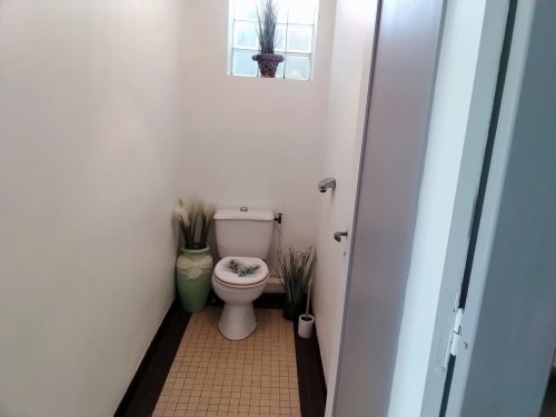 Banheiro do apartamento Maison de Barlest com vaso sanitário, plantas decorativas e piso em azulejos